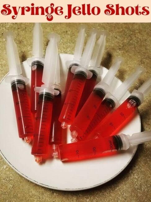 a white plate topped with lots of red and clear bottles filled with liquid on top of a counter