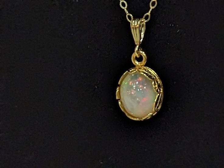 This beautiful necklace is constructed with a  8x10mm oval AAA Ethiopian welo fire opal  cabochon nestled in a 14k gold filled floral bezel pendant.The bezel is connected to a 14k gold filled  corrugated bail  with a 1.6x2.0mm flatlink cable  14k gold filled chain . The closure is  a 5mm 14k gold filled spring clasp that hold the necklace securely as well as the 14k gold filled 20 gauge jump rings that contribute to this well made necklace. The necklace comes in 3 sizes 16,18,and 20 inch chain. Dainty Yellow Gold Oval Cabochon Jewelry, Delicate Gold Opal Jewelry, Fine Jewelry Opal In Gold, Fine Gold Opal Jewelry, Handmade Gold Jewelry With Oval Cabochon, Handmade 14k Gold Oval Cabochon Jewelry, Dainty Ethiopian Opal Jewelry For Anniversary, Gold Opal Fine Jewelry, Gold Oval Cabochon Jewelry As A Gift