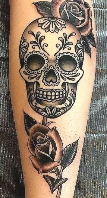 a woman's leg with a skull and rose tattoo on it