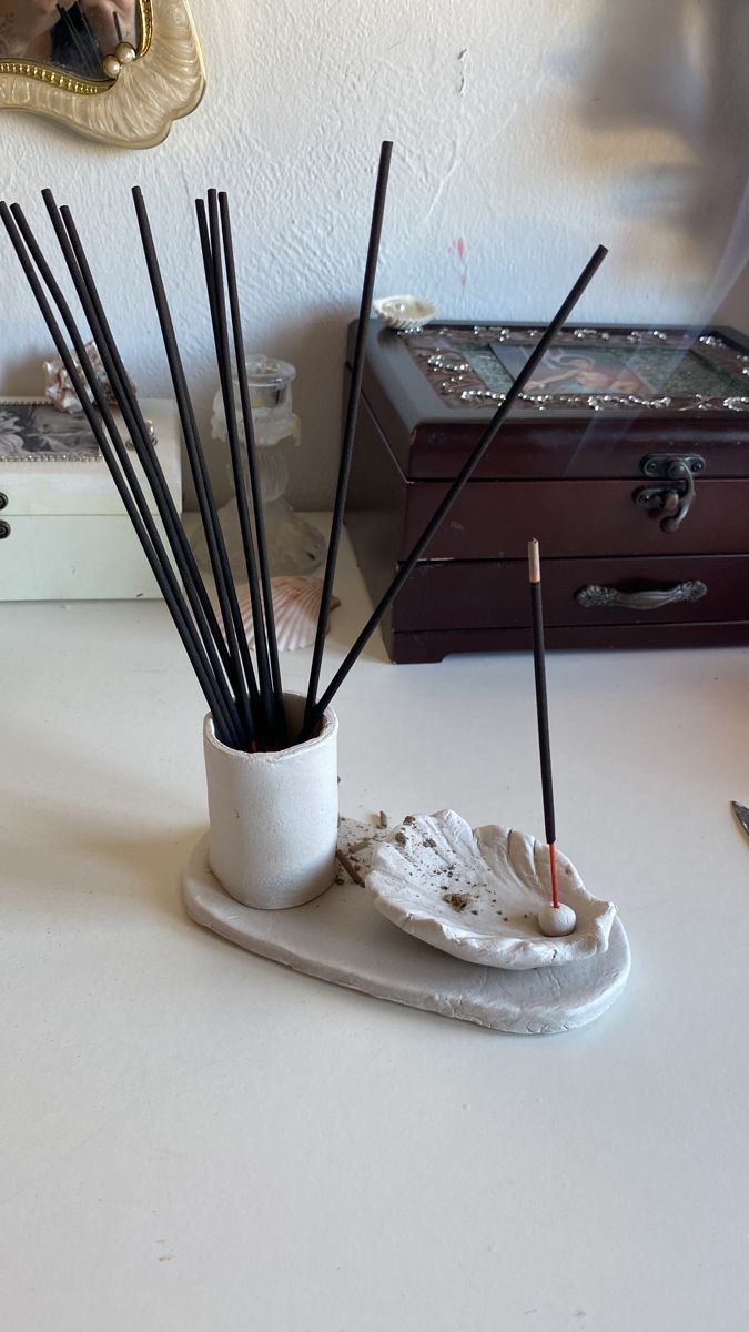 a white table topped with a cup filled with candles