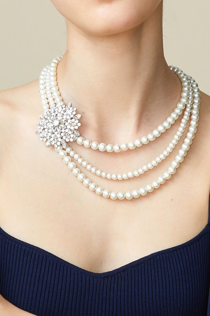 This sumptuous piece of jewelry features a retro-elegant yet slightly modern style that complements the lavish garments, reminiscent of the roaring 1920s. Features: Lustrous imitation pearls Necklace and earrings set Rhinestone studded flower pattern Pearl strand lengths: 15.3", 17.1", 18.1" *The item is flash sale and cannot be returned or exchanged. 3 Strand Pearl Necklace, 1920s Pearl Necklace, 1920 Accessories, Roaring 20s Jewelry, 20s Jewelry, Pearl Ideas, Roaring 1920s, 1920s Jewelry, Layered Pearl Necklace