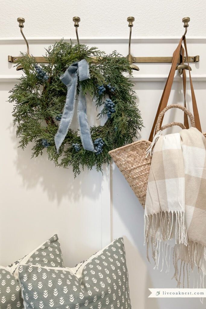 two wreaths hanging on the wall next to pillows