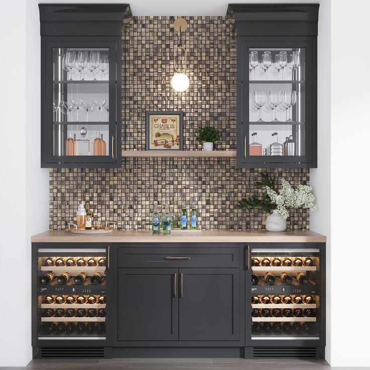 a kitchen with cabinets and wine glasses on the counter top, in front of a tiled backsplash