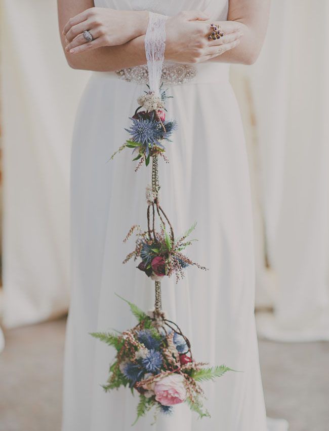 a woman in a white dress is holding her hands on her hips with flowers attached to it