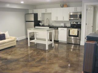 a kitchen and living room are shown with white cabinets, stainless steel appliances, and marble flooring