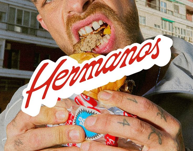 a man eating a doughnut with the word hermanos on it's sticker