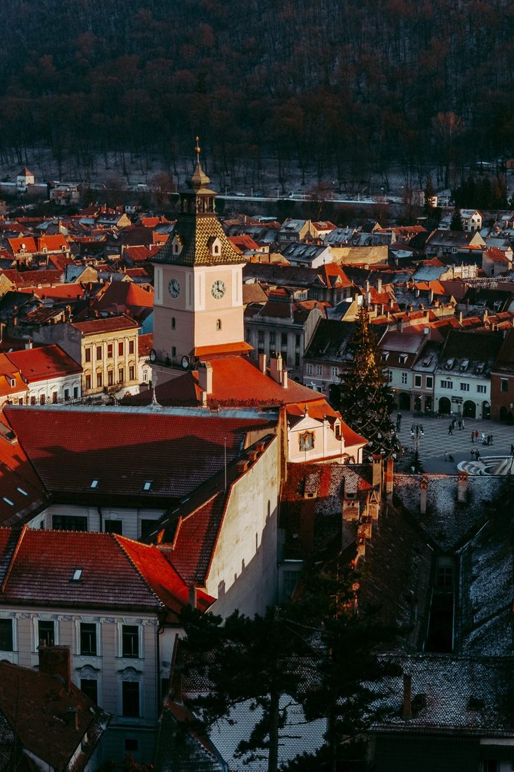 an aerial view of a city with red roofs and steeple buildings in the foreground