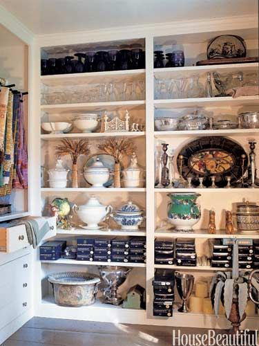 an organized pantry with lots of items on the shelves and dishes in bowls, pans, etc