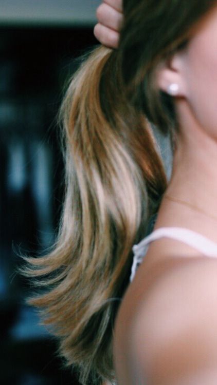 a close up of a woman brushing her hair