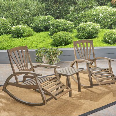 three wooden rocking chairs sitting on top of a patio floor next to a potted plant