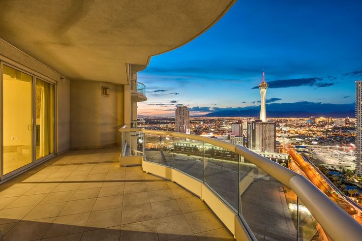 a balcony overlooking the city lights at night with glass railings and balconies