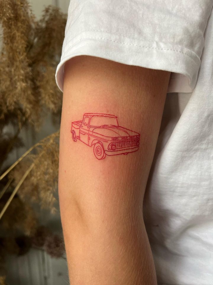 a red line drawing of a pickup truck on the arm