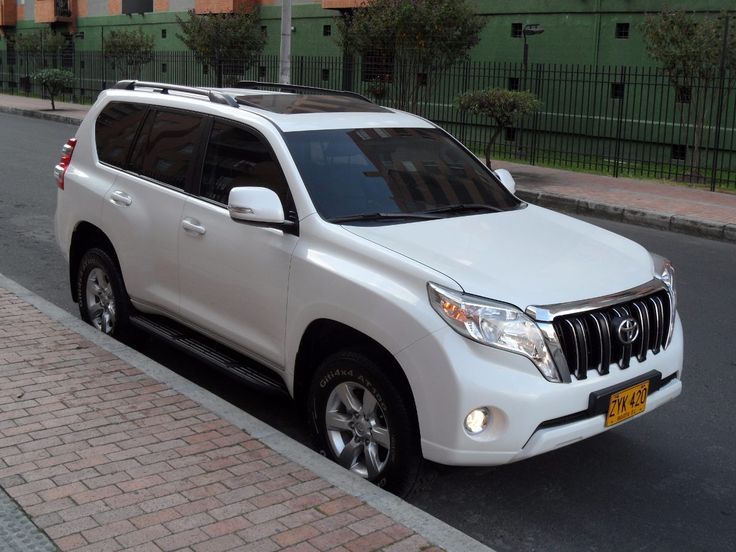 a white suv is parked on the side of the road