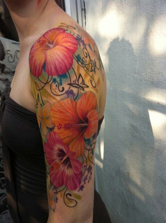 a woman's arm with flowers on it and an orange flower in the middle