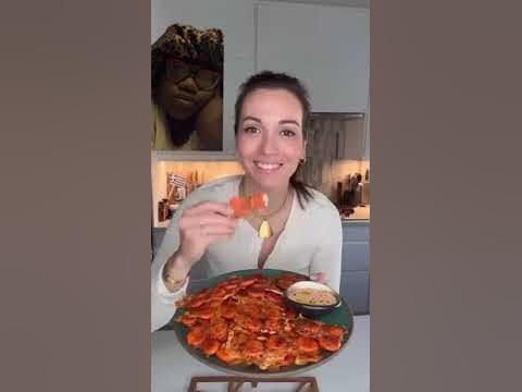 a woman holding up a plate of food