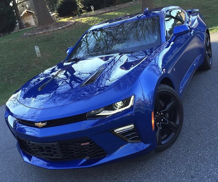 a blue chevrolet camaro is parked on the street