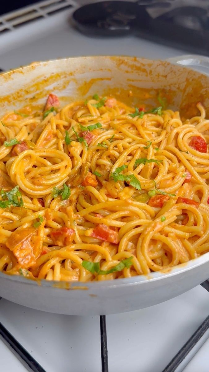 a pan filled with pasta and vegetables on top of a stove