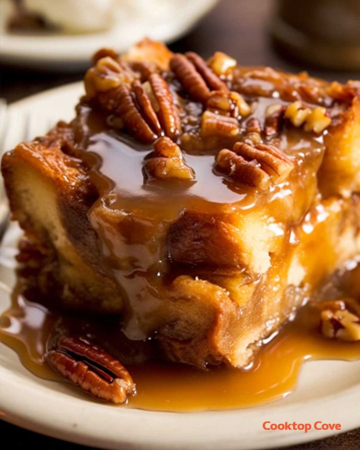 a piece of pecan bread pudding on a plate with caramel sauce and pecans