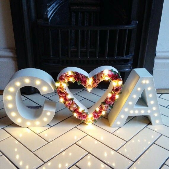 the letters are decorated with lights and flowers