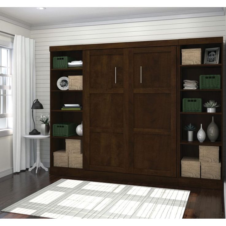 a living room with a large bookcase and white rug in front of the window