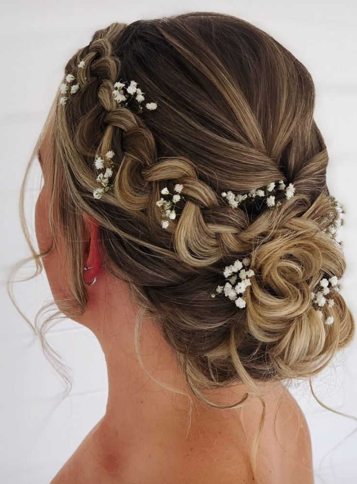 a woman with braids and flowers in her hair is looking back at the camera