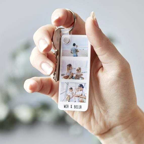 a person holding a keychain with pictures on it