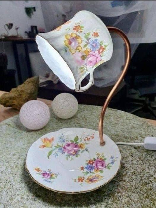 a tea cup and saucer sitting on top of a table next to a rock