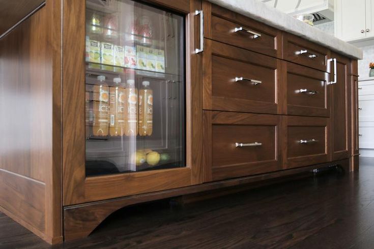 a kitchen with wooden cabinets and an icebox in the center, on top of a hard wood floor