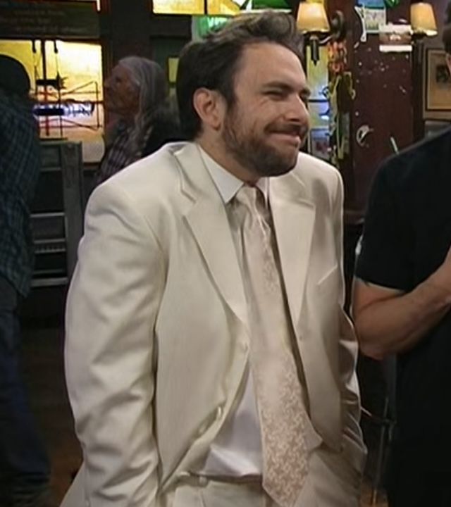 two men standing next to each other in front of a bar wearing suits and ties