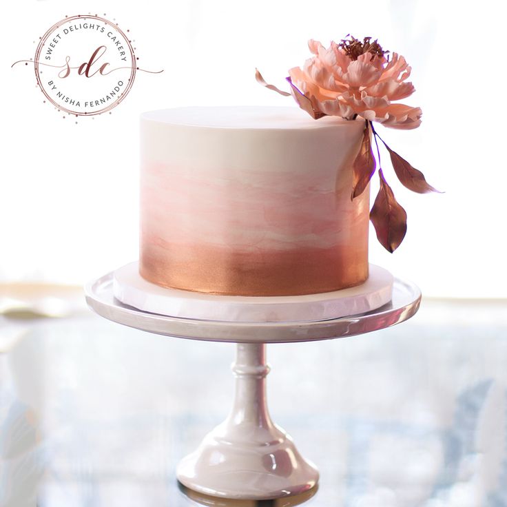 a white and pink cake sitting on top of a table