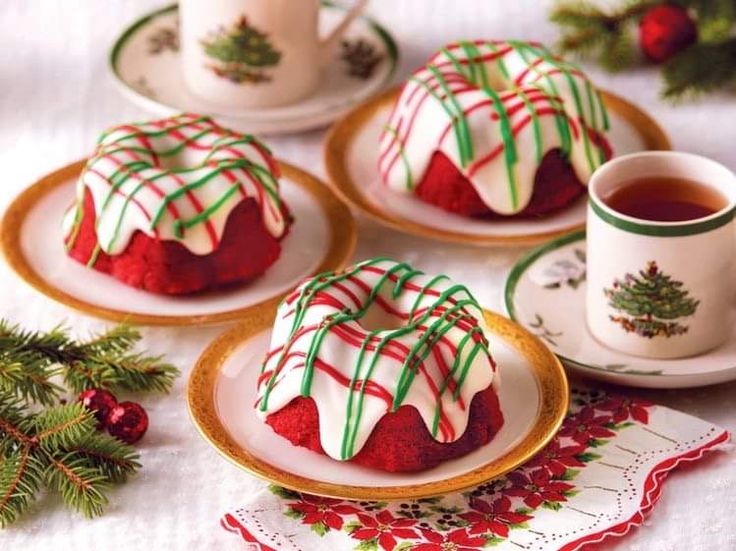 red velvet desserts with white and green icing on plates next to a cup of tea