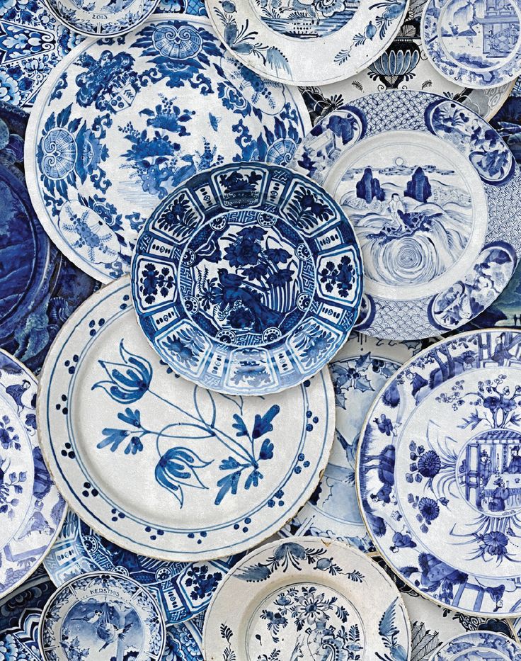 many blue and white plates stacked on top of each other