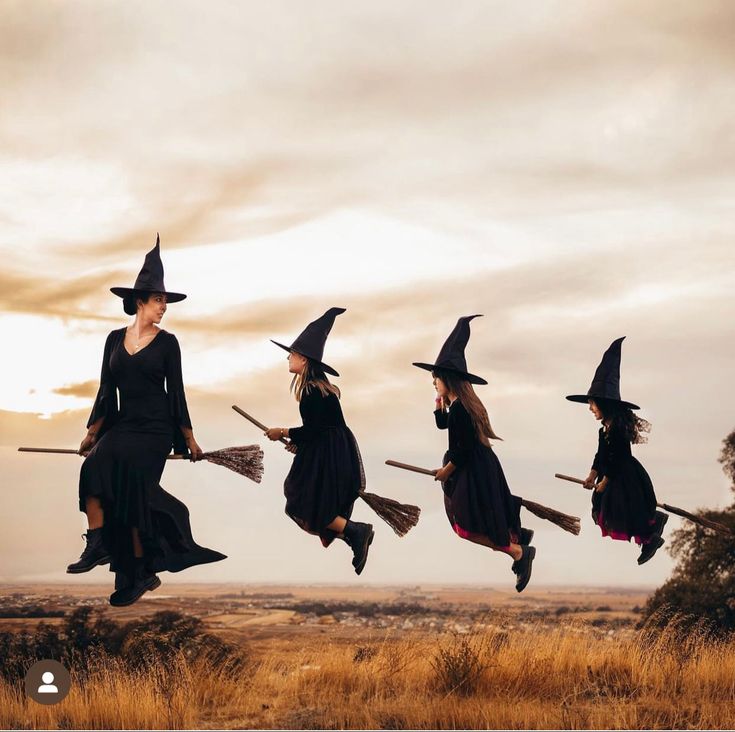 a group of women dressed in witches flying through the air with brooms on their heads