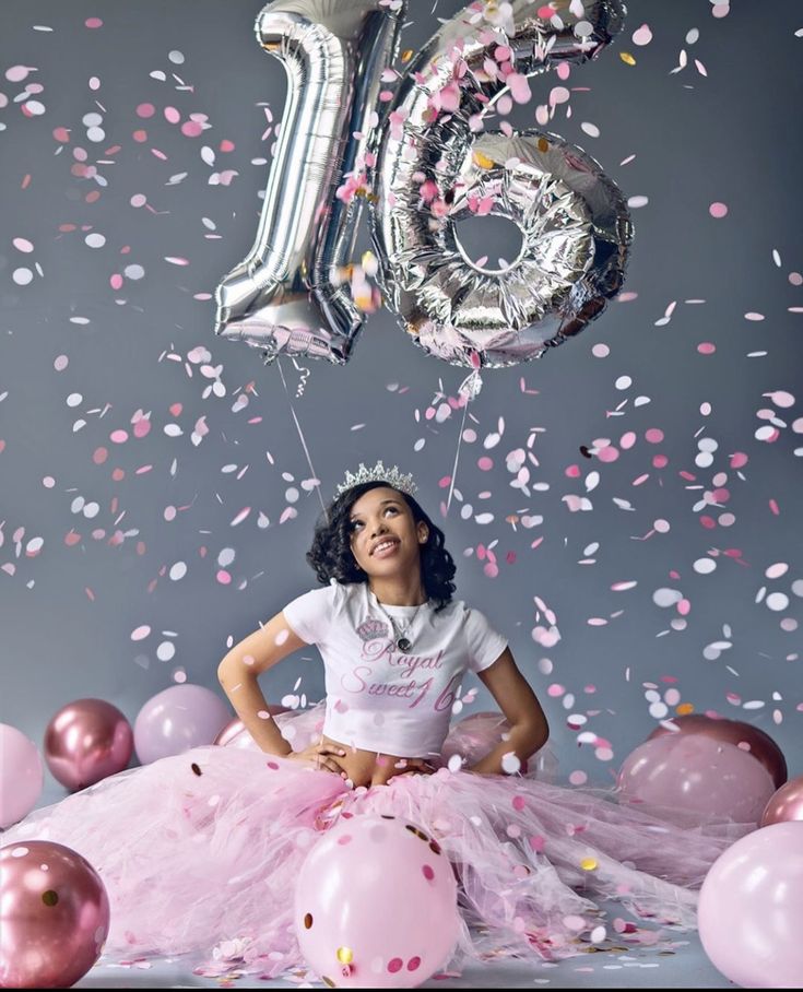 a girl in a pink tutu surrounded by balloons and streamers with the number twenty five