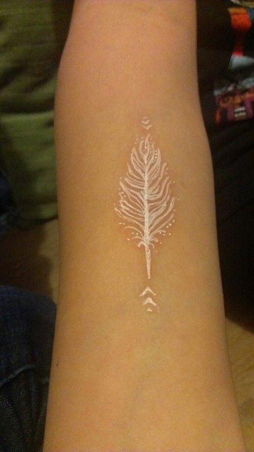 a white feather tattoo on the wrist and arm, it looks like something from another world