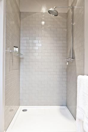 a walk in shower sitting next to a white towel