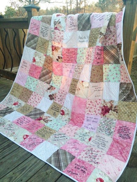 a pink and brown quilt sitting on top of a wooden deck