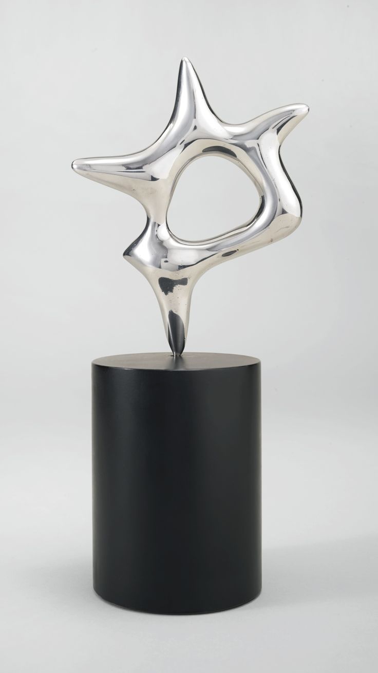 a silver sculpture sitting on top of a black stand