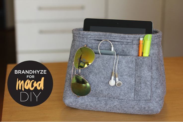 a gray bag with sunglasses, headphones and earbuds in it sitting on a table