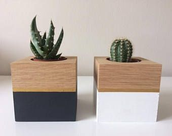 two small wooden planters sitting on top of a white table