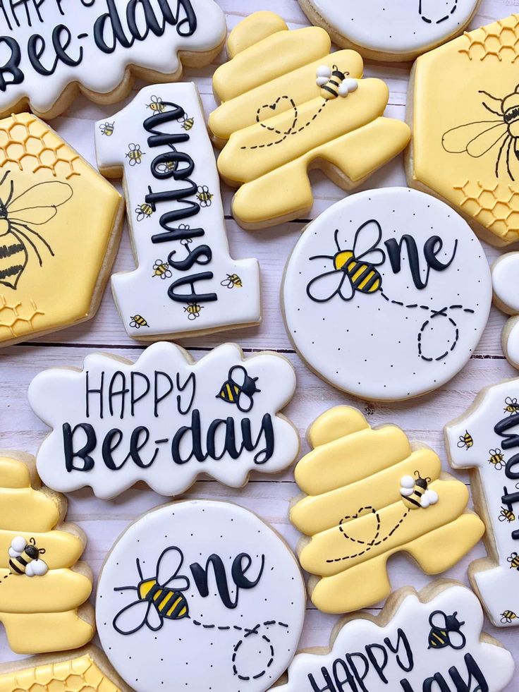 decorated cookies that say happy bee - day, one honey and two bees on them