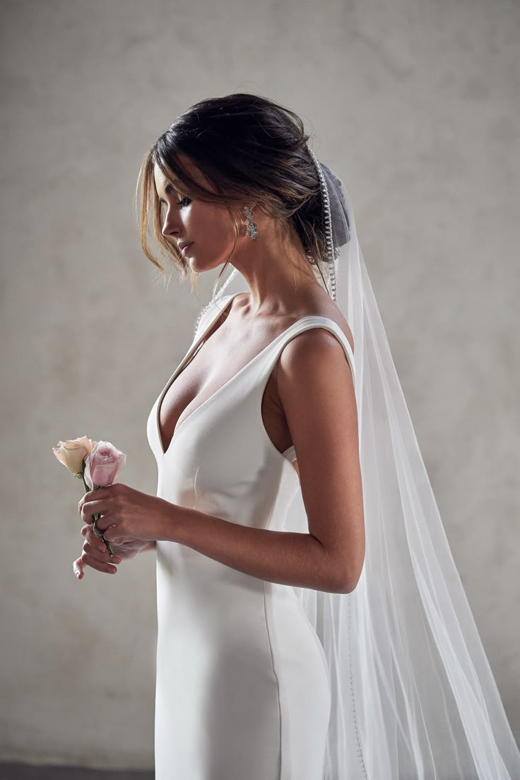 a woman in a wedding dress holding a flower