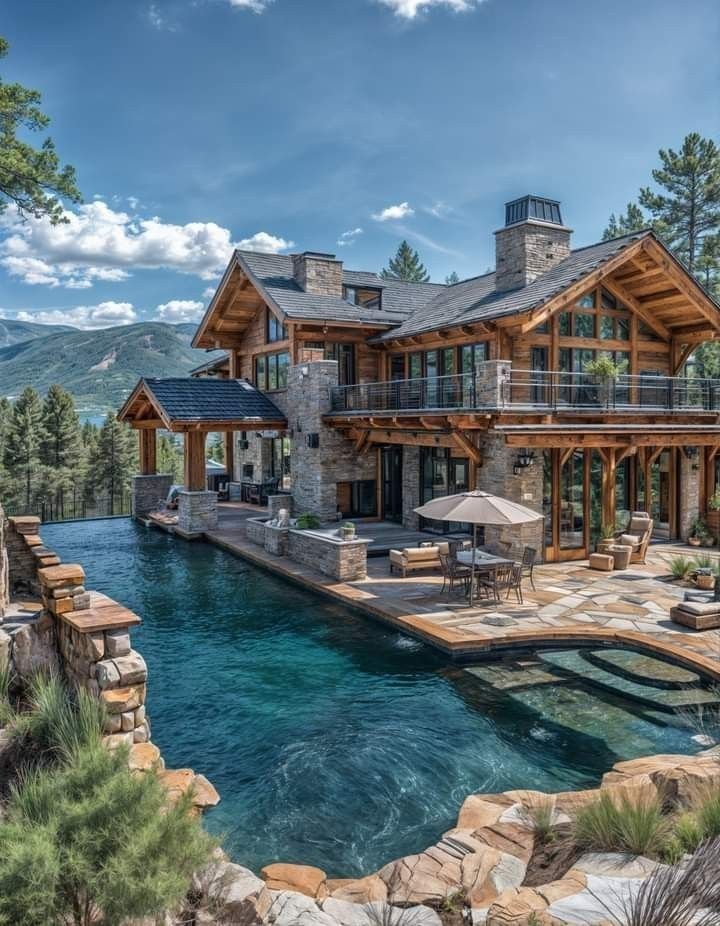 a large house with a pool in front of it and an outdoor dining area next to it