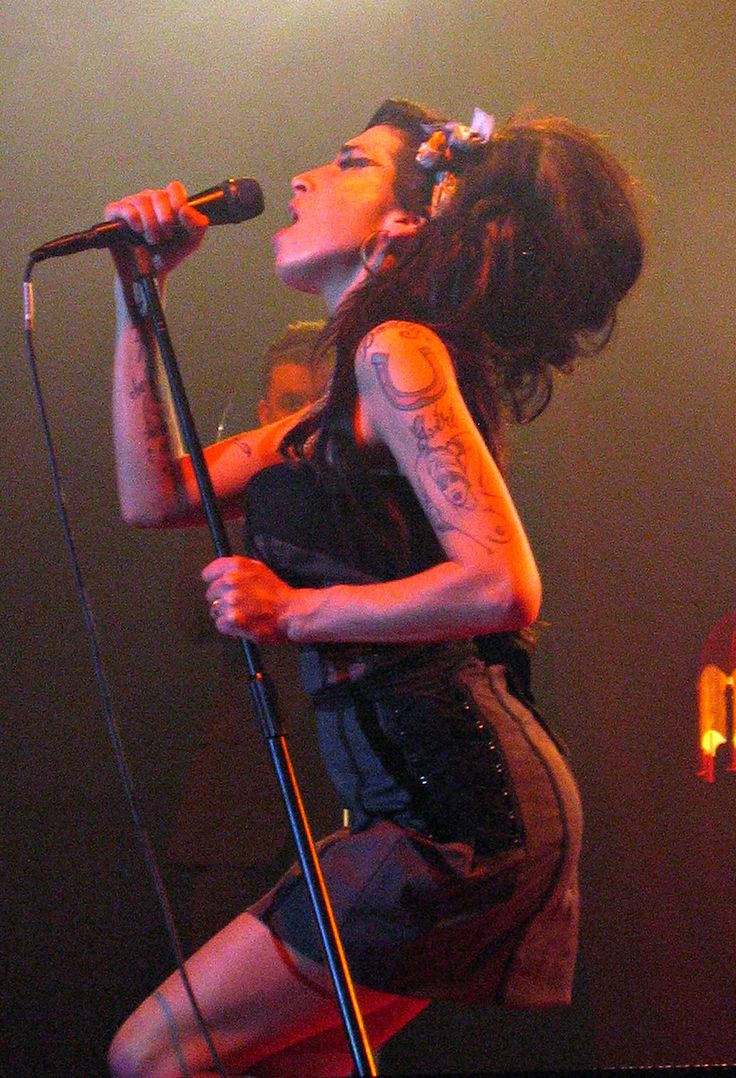 a woman on stage singing into a microphone