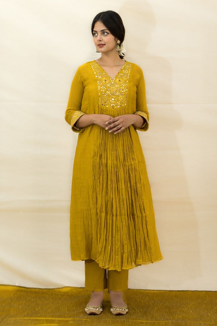 Mustard malai chanderi tunic with mirror, resham and zardosi hand embroidered yoke and cuffs. Comes with slim-fit pant and a slip.
Components: 3
Pattern: Hand embroidered
Type Of Work: Mirror, Resham, Zardosi
Neckline: Tunic : V Neck, Slip : Round
Sleeve Type: Tunic : Three quarter, Slip : Sleeveless
Fabric: Malai chanderi, Lining : Mulmul
Color: Yellow
Other Details: 
Closure : Back button
Disclaimer : The natural imperfection and textures in the weaves are the outcome of handloom fabrics (not Handloom Fabric, Embroidered Tunic, Fashion App, Slim Fit Pants, Pant Set, Set For Women, Aza Fashion, Sleeve Type, Three Quarter