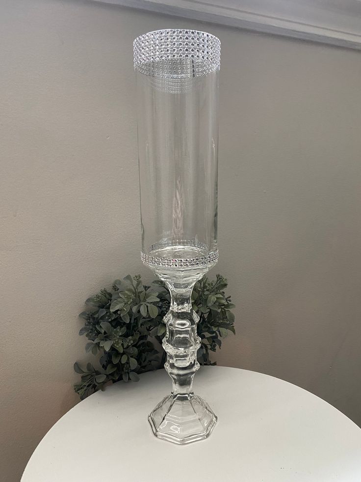 a clear vase sitting on top of a white table