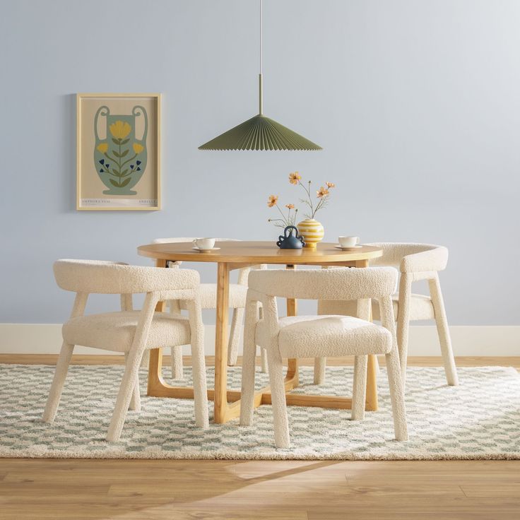 a dining table with four chairs and a potted plant on the table next to it