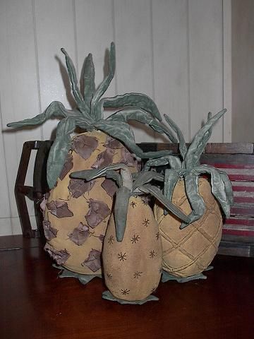 two decorative pineapples sitting on top of a wooden table