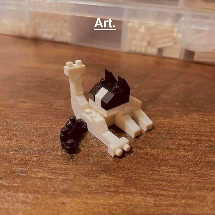 a lego cat sitting on top of a wooden table