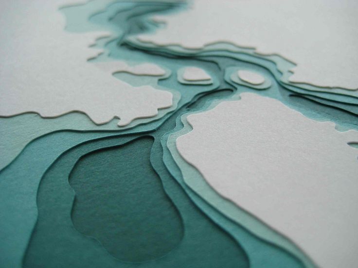 a close up view of the water and land in this photo, it looks like an abstract piece of paper